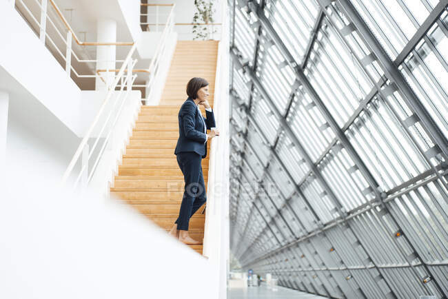 Professionista femminile in piedi su gradini in corridoio — Foto stock