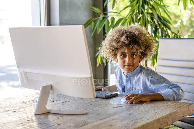 Afro garçon assis devant l'ordinateur à la maison — Photo de stock
