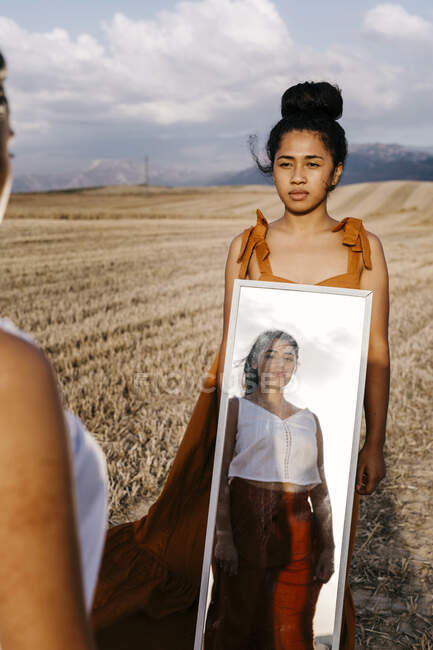 Femme avec reflet d'amie sur le miroir au champ — Photo de stock