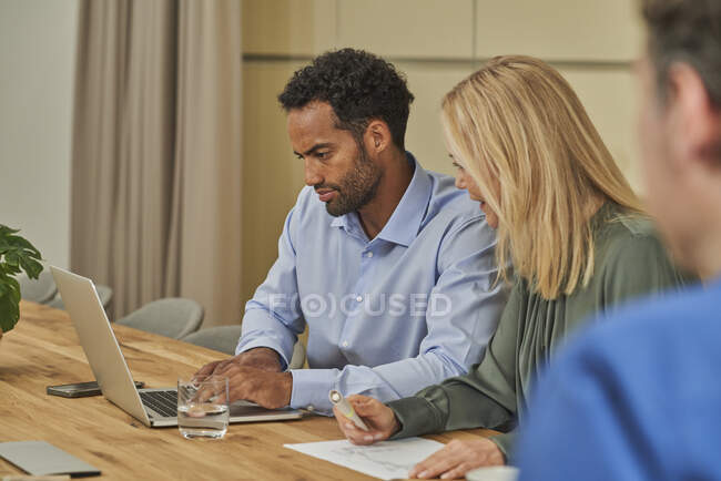 Männliche und weibliche Kollegen diskutieren bei Besprechung über Laptop — Stockfoto