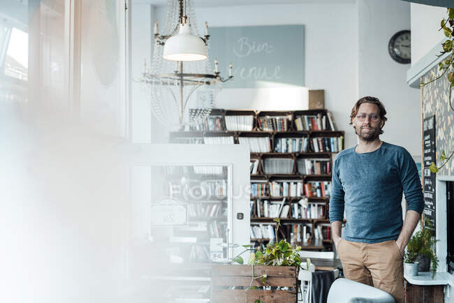 Мужчина-предприниматель с руками в карманах стоит в кофейне — стоковое фото