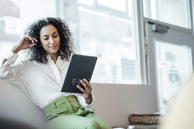 Giovane donna d'affari che utilizza tablet digitale mentre seduto al caffè — Foto stock