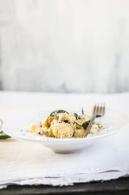 Plate of ready-to-eat Italian gnocchi dumplings with grated Parmesan cheese — Stock Photo