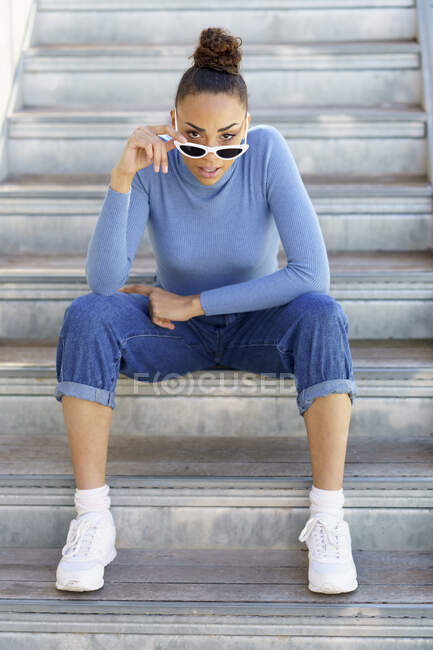 Frau mit Sonnenbrille starrt auf Stufen — Stockfoto