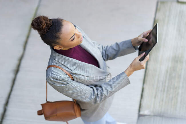 Unternehmer mit Tasche mit digitalem Tablet auf Fußweg — Stockfoto