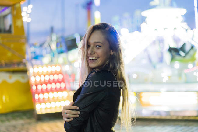 Giovane donna felice su un luna park di notte — Foto stock