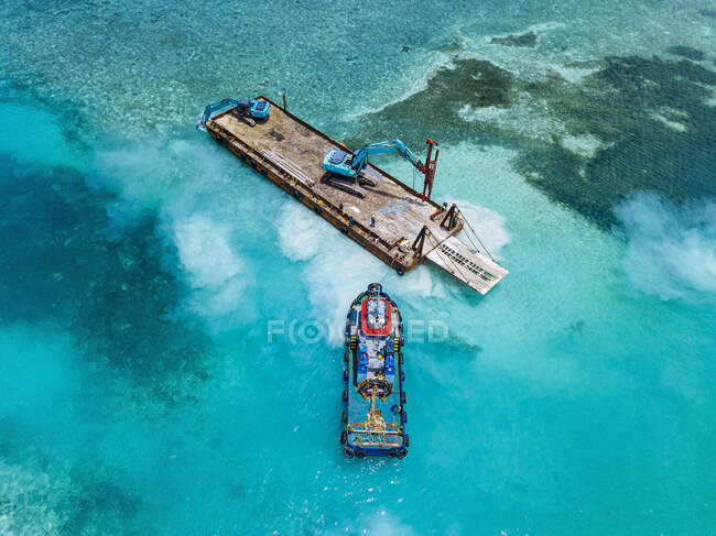 Aerial view of earth movers handling poles on floating platform in Male Atoll — Stock Photo