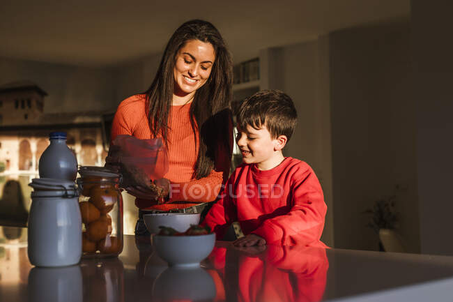 Щаслива мати й син разом готують сніданок. — стокове фото