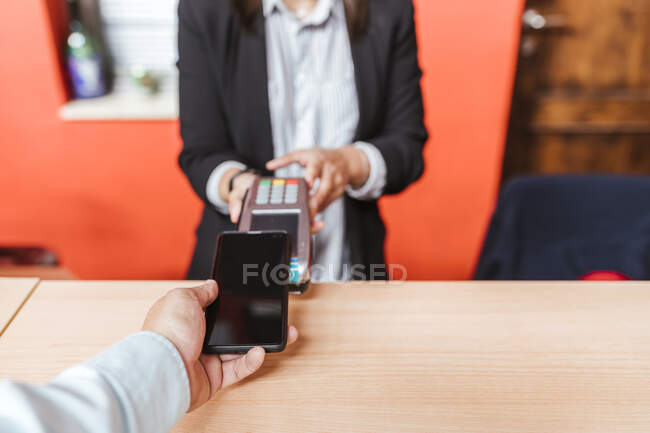 Male customer doing contactless payment from smart phone at warehouse checkout — Stock Photo