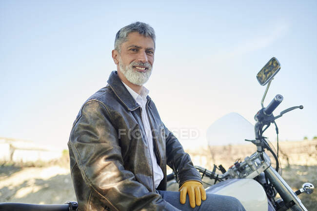 Homem relaxado sentado em moto durante a viagem de carro — Fotografia de Stock