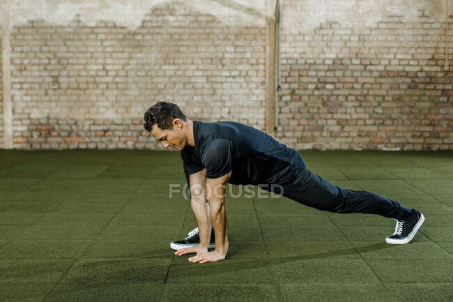 Homme faisant de l'exercice contre le mur au club de santé — Photo de stock