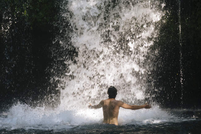 Indonesia, Bali, Man bathing in waterfall — Stock Photo