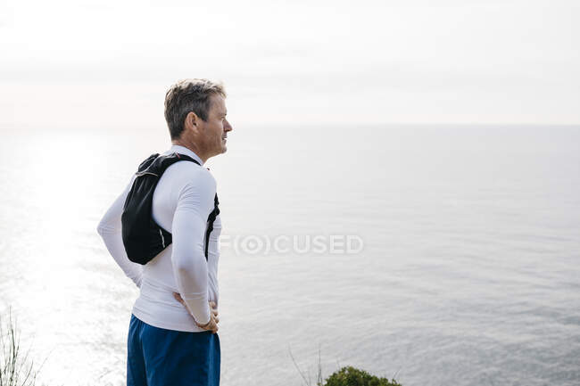 Mann steht mit Hand auf hüfthoher See gegen klaren Himmel — Stockfoto