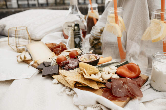 Close-up of food and drink on blanket on rooftop — Stock Photo