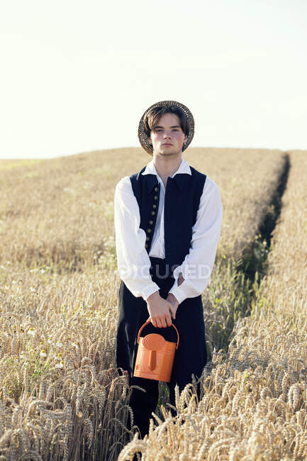 Хлопчик-підліток, що тримає полив, може стояти на полі — стокове фото