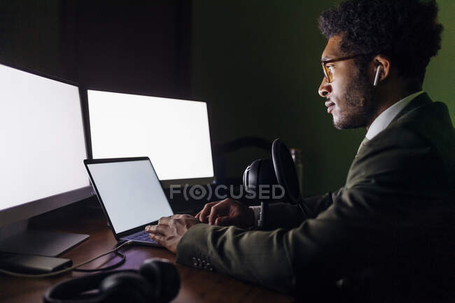 Businessman with microphone using laptop while working at home office — Stock Photo