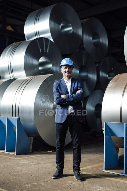 Male business professional standing with arms crossed at warehouse — Stock Photo