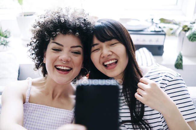 Fröhliche Freundinnen machen Selfie per Smartphone zu Hause — Stockfoto