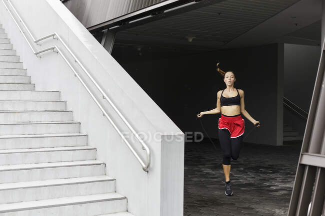 Atleta donna che salta in cantina — Foto stock