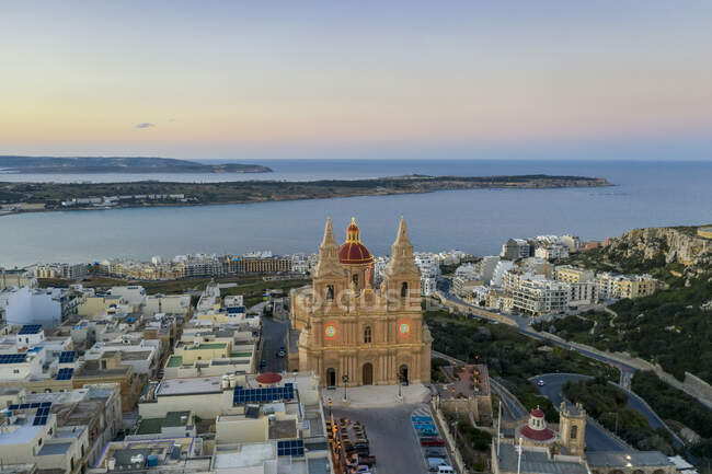 Malta, Região Norte, Mellieha, Vista aérea da Igreja Paroquial da Natividade da Virgem Maria ao entardecer com a Baía de Ghadira em segundo plano — Fotografia de Stock