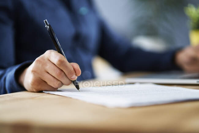 Businessman signing documents while working from home — Stock Photo