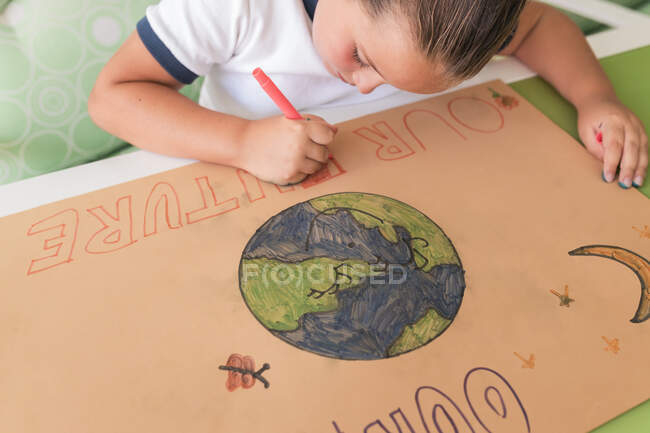 Girl writing on cardboard paper at home — Stock Photo