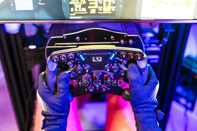 Controlador de retención de gamer masculino mientras juega videojuego en el estudio - foto de stock