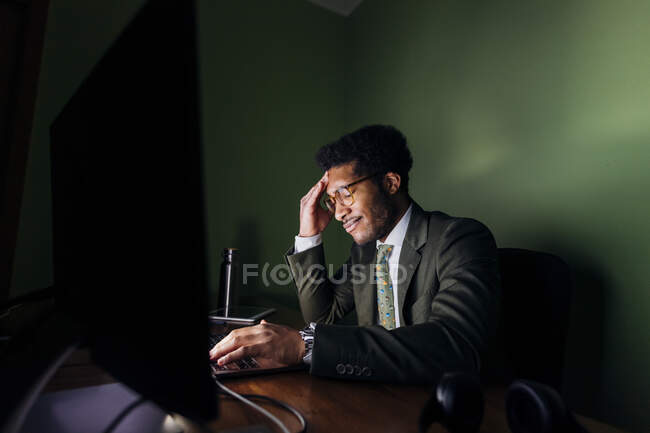 Чоловічий професійний сидячий з головою в руках у домашньому кабінеті. — стокове фото
