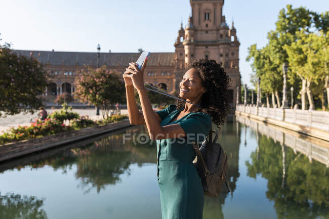 Посмішка серед жінок - туристів, які самовіддано користуються смарт - телефоном біля Пласа - де - Ессана (Севілья, Іспанія). — стокове фото