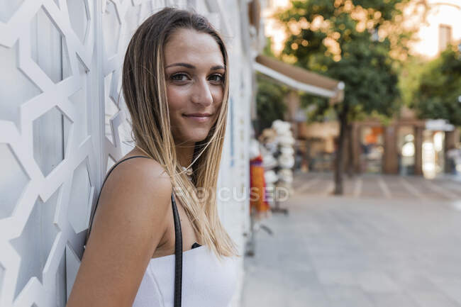 Mulher loira jovem bonita inclinando-se na parede — Fotografia de Stock