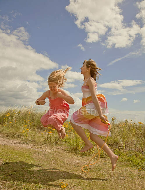 Ragazze che giocano con corda da salto in spiaggia durante la giornata di sole — Foto stock