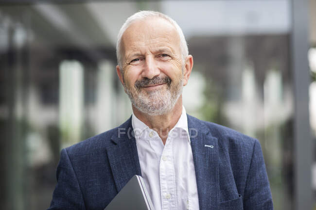 Happy senior businessman with laptop — Stock Photo