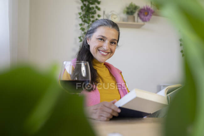 Красивая женщина с книгой, сидящая дома — стоковое фото