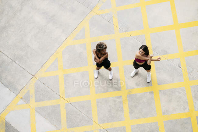 Mid adult women doing warm up exercise on footpath — Stock Photo