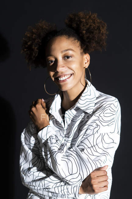 Afro mujer sonriendo sobre negro fondo - foto de stock