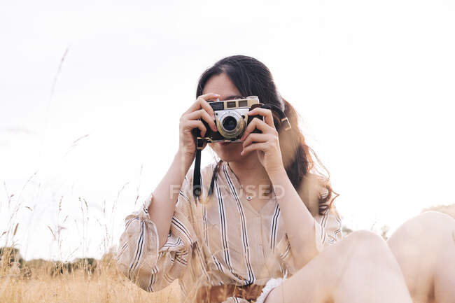 Donna che fotografa attraverso la fotocamera al parco — Foto stock