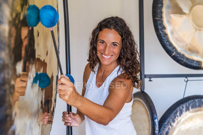 Thérapeute sonore souriant jouant de l'instrument de musique avec des maillets — Photo de stock