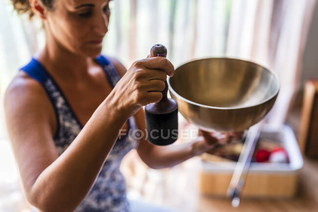 Mujer jugando tazón de bronce en el estudio - foto de stock