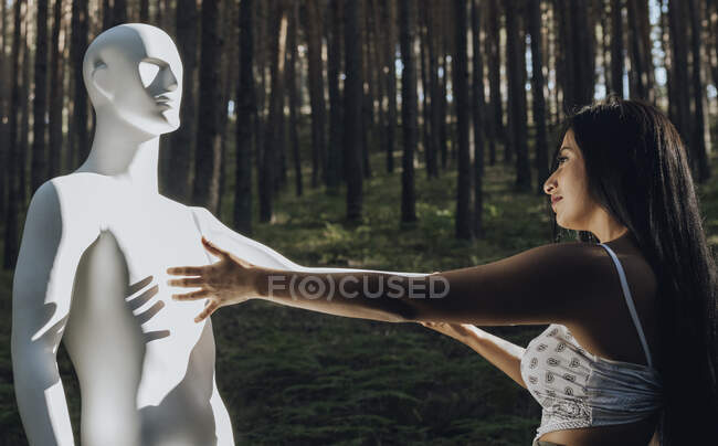 Молодая женщина смотрит на робота в солнечный день — стоковое фото