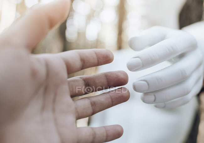 Руки женщины и робота касаются — стоковое фото