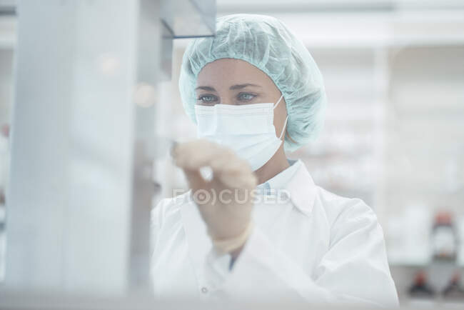 Farmacista femminile con maschera protettiva che lavora in farmacia — Foto stock