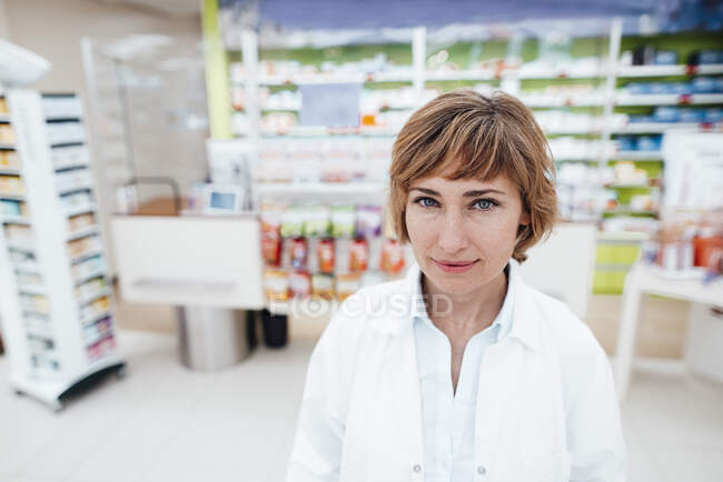 Sonriente profesional femenina en la farmacia - foto de stock