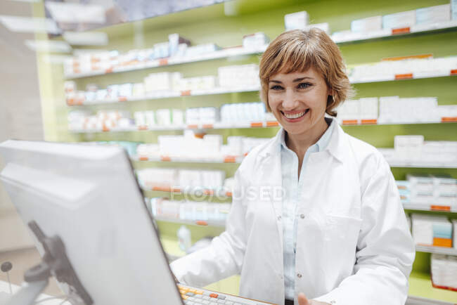 Joyeuse pharmacienne debout en magasin — Photo de stock