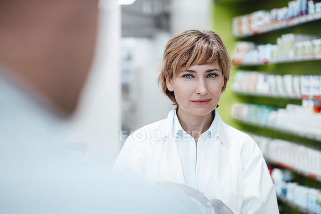 Bionda farmacista femminile in piedi al negozio di medicina — Foto stock