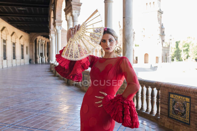 Mulher vestindo vestido tradicional segurando ventilador de mão na passarela Plaza De Espana em Sevilha, Espanha — Fotografia de Stock