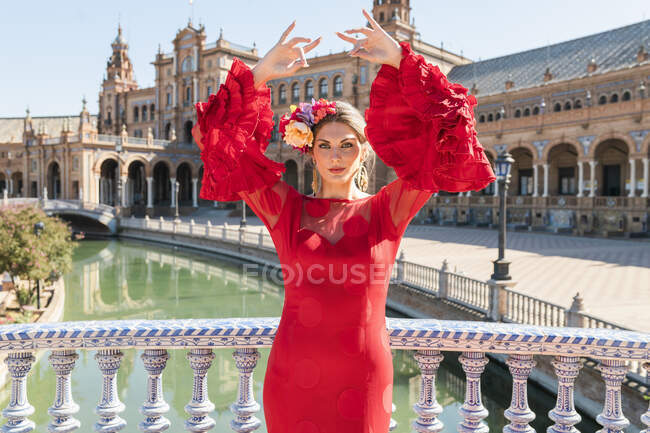 Танцовщица в красном платье, стоящая на площади Испании в Севилье — стоковое фото