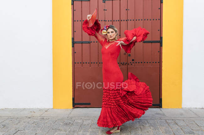 Artista donna con ventaglio a mano che balla davanti alla porta — Foto stock
