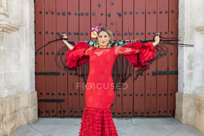 Female flamenco dancer holding shawl while spinning in front of door — Stock Photo