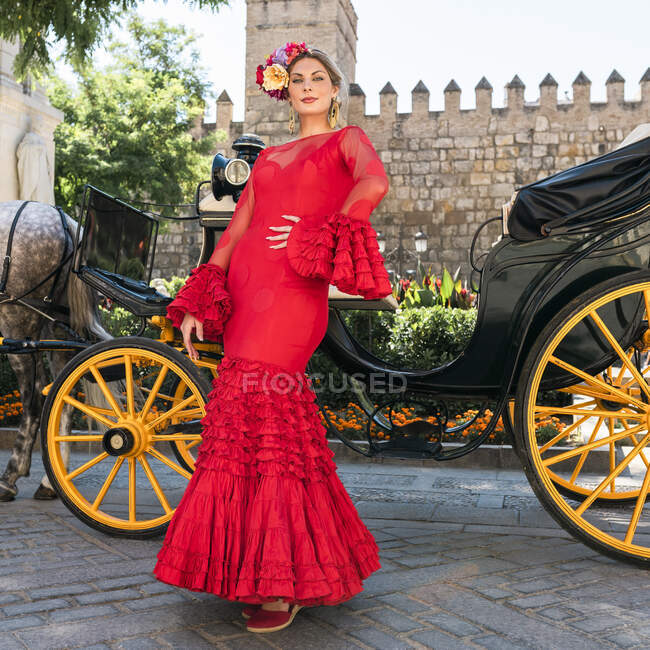 Танцівниця у сукні фламенко стоїть біля воза. — стокове фото