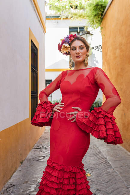 Жінка-художник у червоному традиційному вбранні стоїть на алеї. — стокове фото
